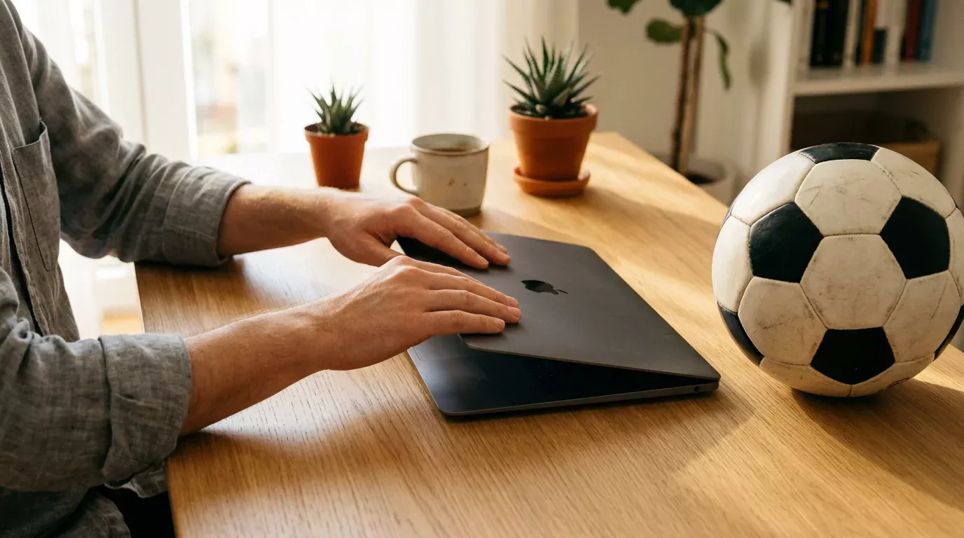 Manos cerrando un portatil junto a un balon de futbol simbolizando autocontrol